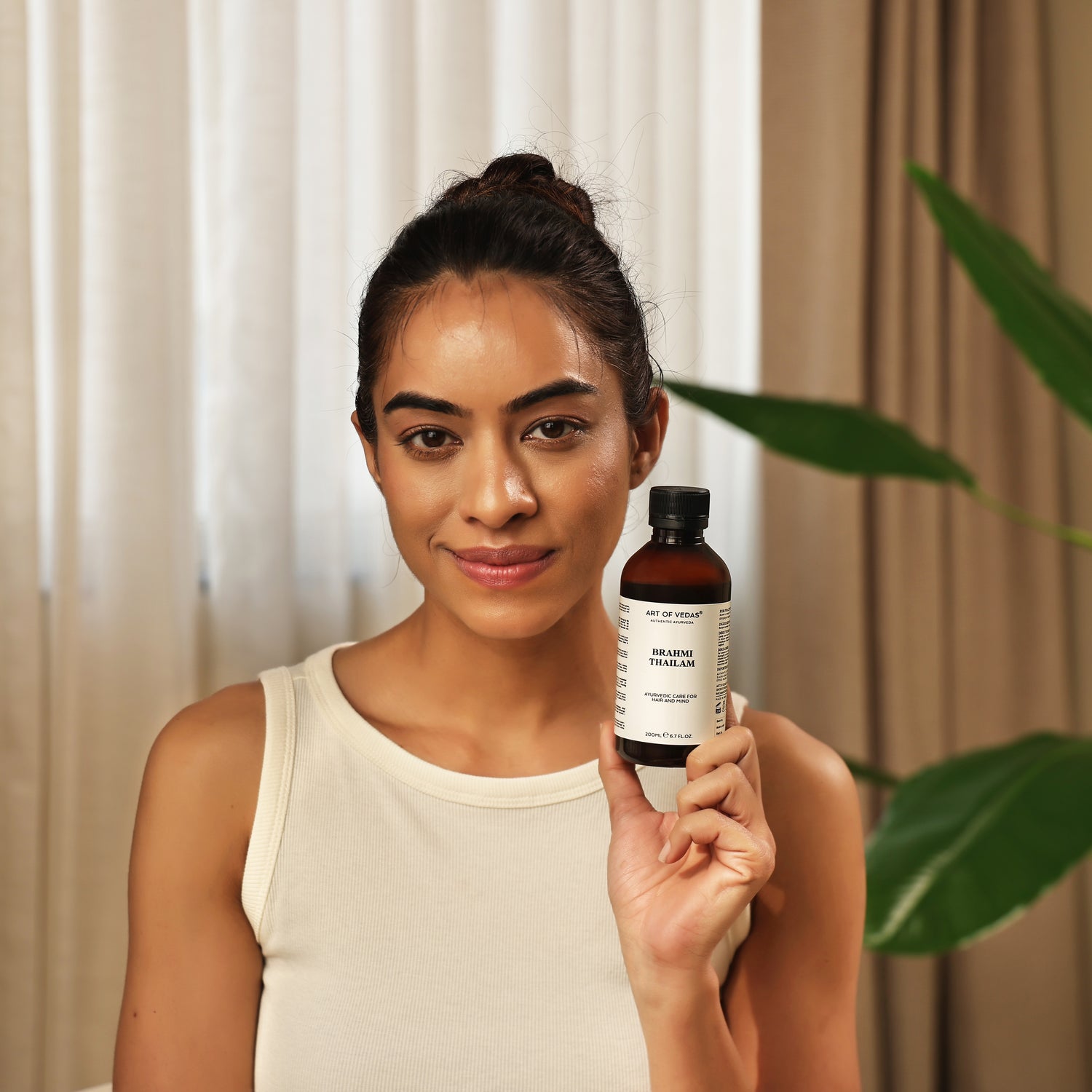 Art of Vedas Brahmi Thailam Ayurvedic Hair Oil - Woman Holding Brahmi Oil Bottle for Hair Nourishment and Scalp Care